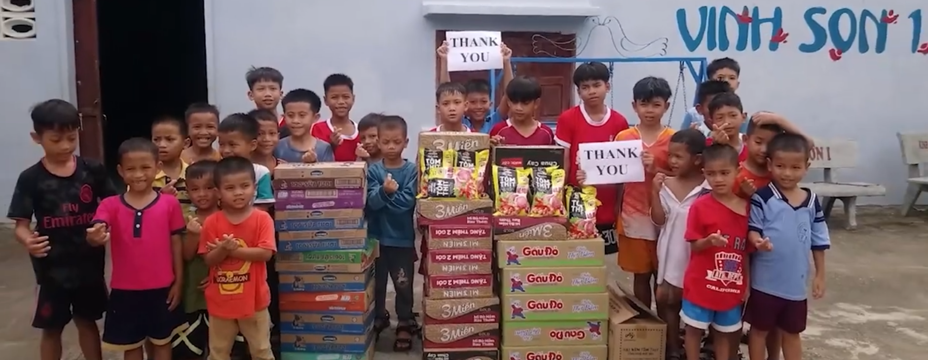 Orphanage children smiling, holding thank you sign, donated food Vietnam, Vinh Son Orphanage, Kon Tum charity, Vietnam B2B Direct, children receiving aid, grateful kids, food donation impact, helping Vietnamese orphans, community support, feeding hope, humanitarian aid Vietnam, ethnic minority support, child welfare Vietnam